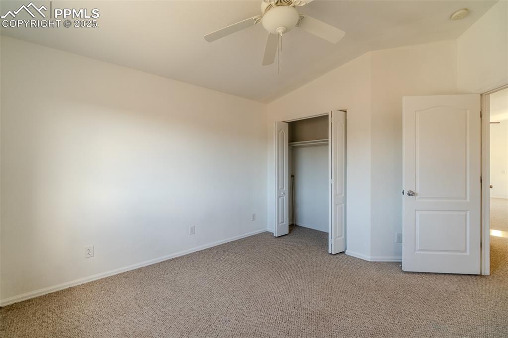 Image 13 of 36: Unfurnished bedroom featuring carpet flooring, lofted ceiling, a closet, an