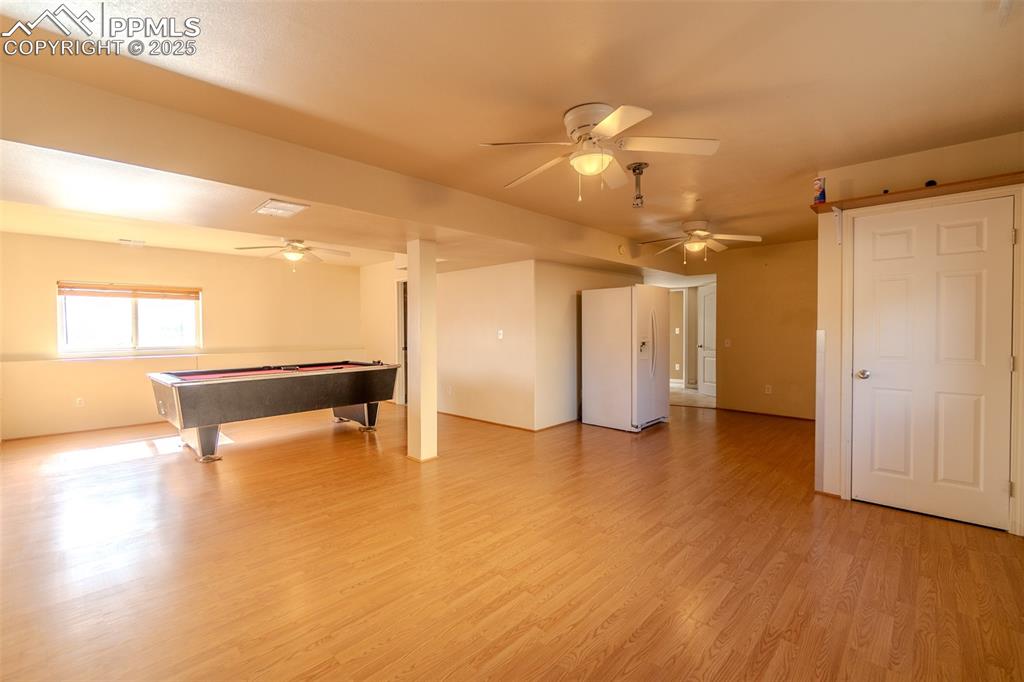 Image 19 of 36: Playroom with light wood-style floors, a ceiling fan, and billiards table
