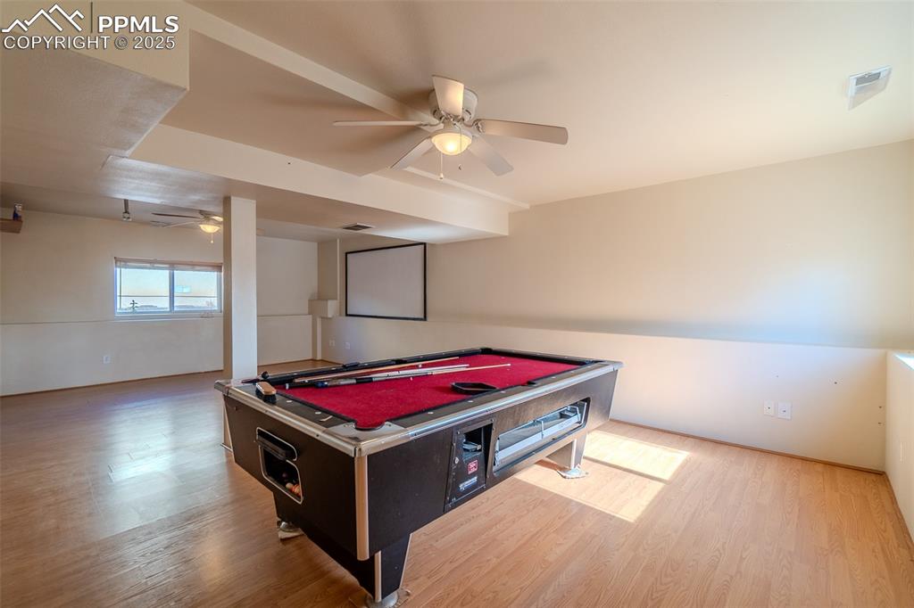 Image 21 of 36: Game room featuring a ceiling fan, billiards, and wood finished floors
