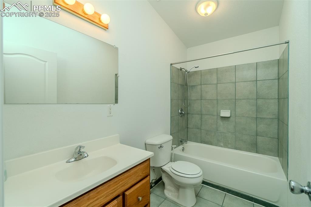 Image 26 of 36: Bathroom with light tile patterned floors, tub / shower combination, and va