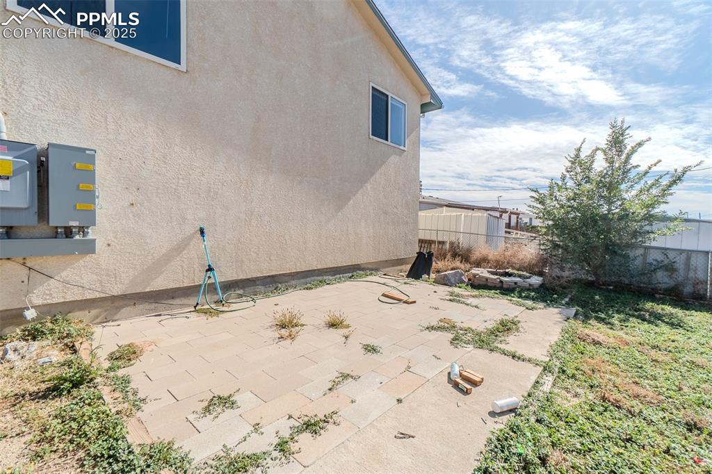 Image 31 of 36: View of side of home with stucco siding and a patio