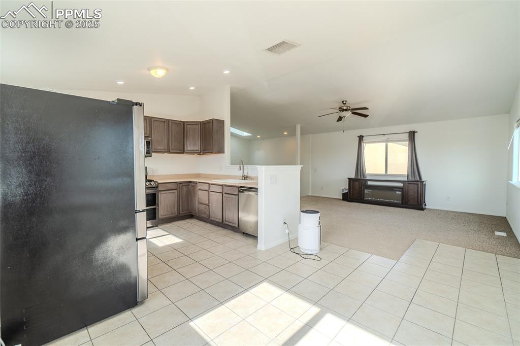 Image 34 of 36: Kitchen featuring appliances with stainless steel finishes, vaulted ceiling