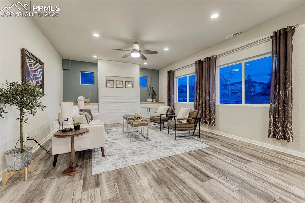 Image 12 of 50: Living area with ceiling fan, light wood finished floors, and recessed ligh