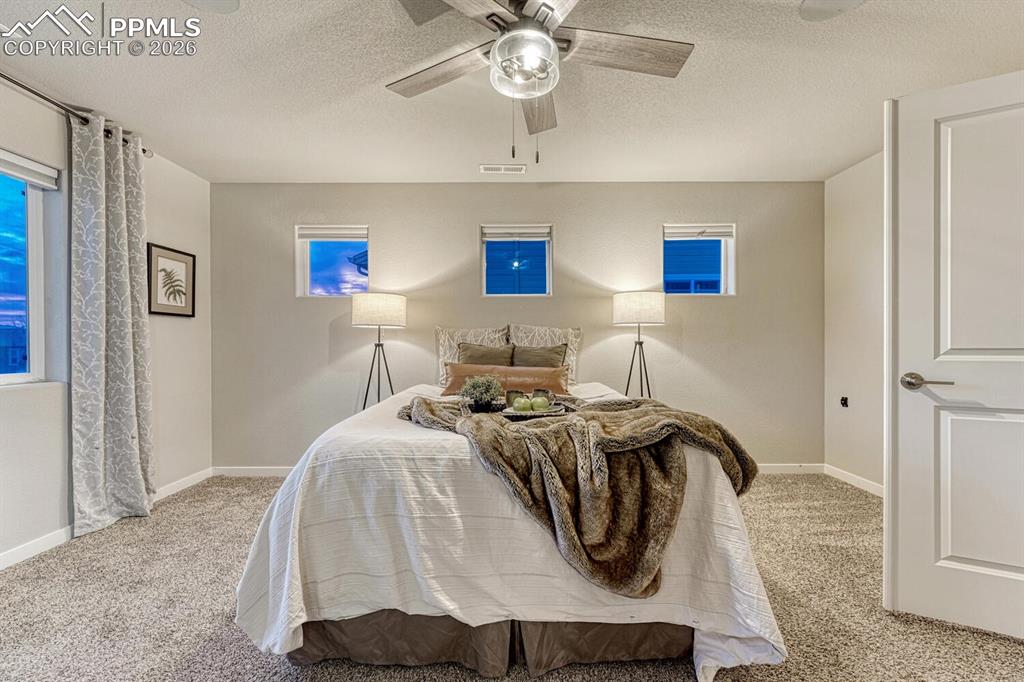 Image 30 of 50: Enter the primary bedroom through stylish French doors with a barn door des