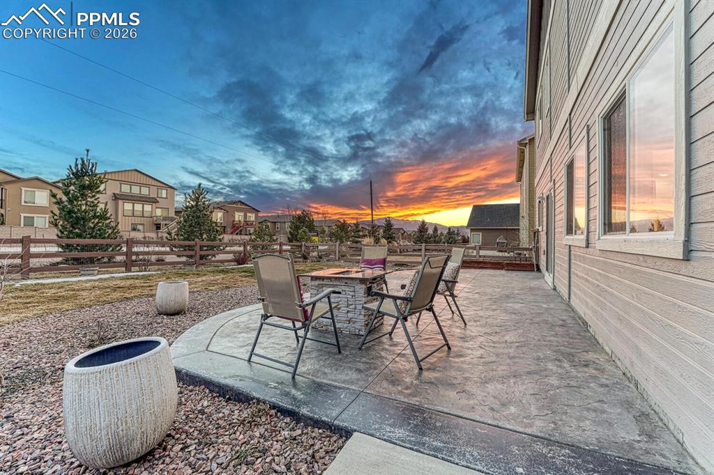 Image 40 of 50: Fenced backyard with a patio area, an outdoor fire pit, and a residential v