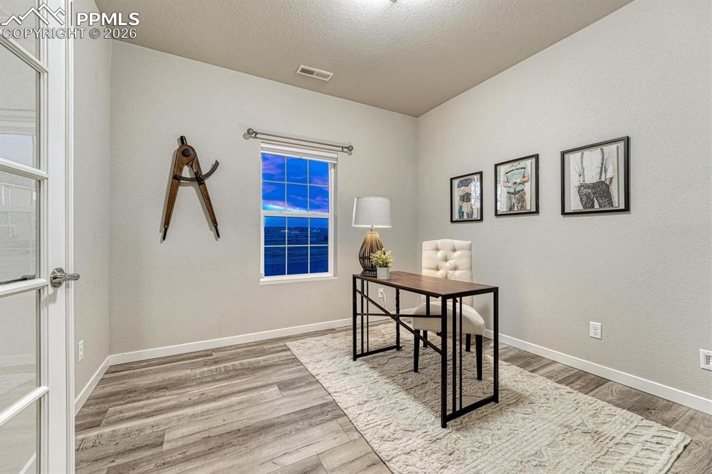 Image 5 of 50: Professional office area with French doors and elegant light-finished floor