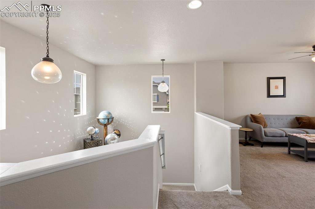 Image 13 of 26: Hall featuring an upstairs landing and carpet floors