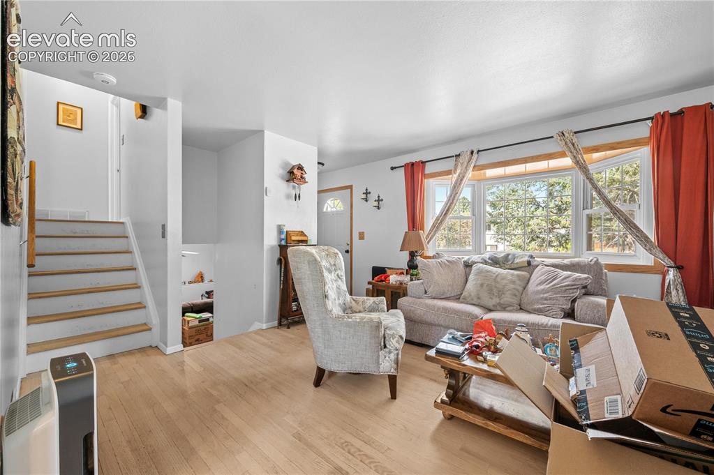 Image 2 of 9: Living room featuring a prominent bay window, light wood-finish flooring, a