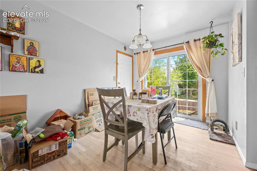 Image 3 of 9: Dining area featuring wood-finish flooring and a contemporary chandelier
