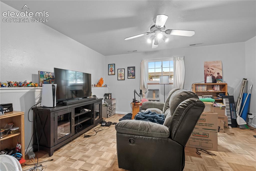 Image 6 of 9: Living area featuring wood-finish flooring, a ceiling fan with integrated l