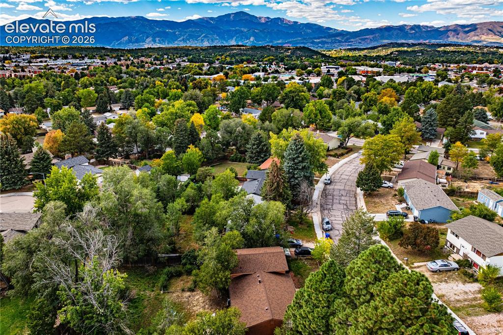 Image 9 of 9: Expansive residential area featuring a curvilinear street, abundant mature 