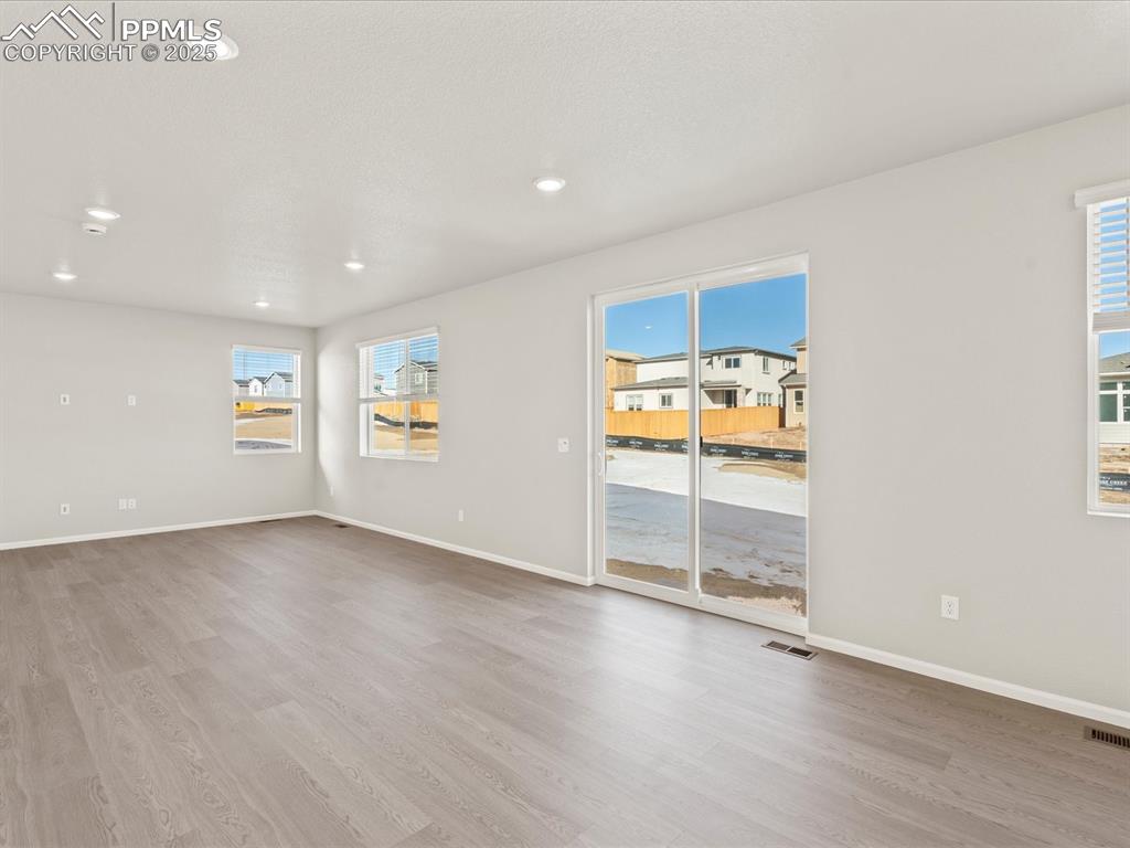 Image 12 of 26: Empty room featuring plenty of natural light, light wood-style floors, and
