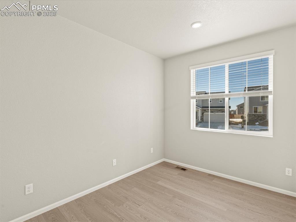 Image 15 of 26: Spare room with baseboards and light wood-style floors