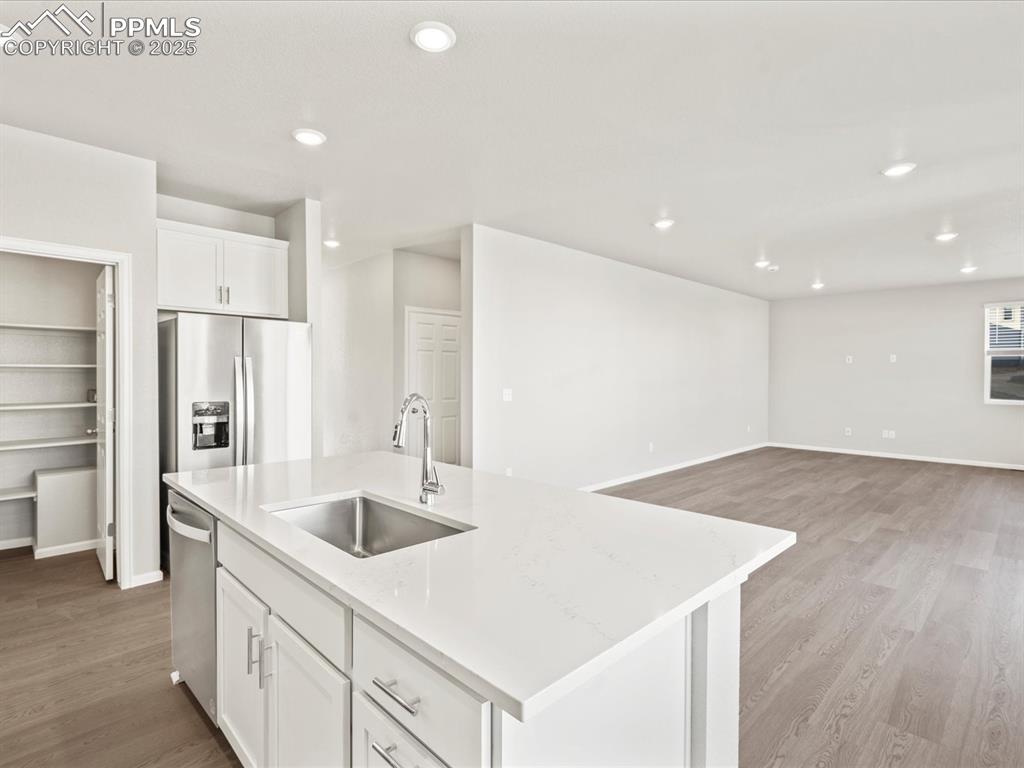 Image 9 of 26: Kitchen featuring white cabinets, light wood finished floors, recessed ligh
