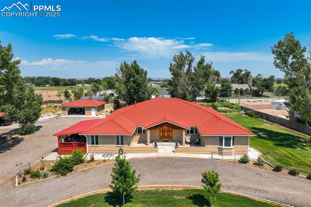 Caption: View of front of property featuring curved driveway, a Decra metal tile roof, and covered porch