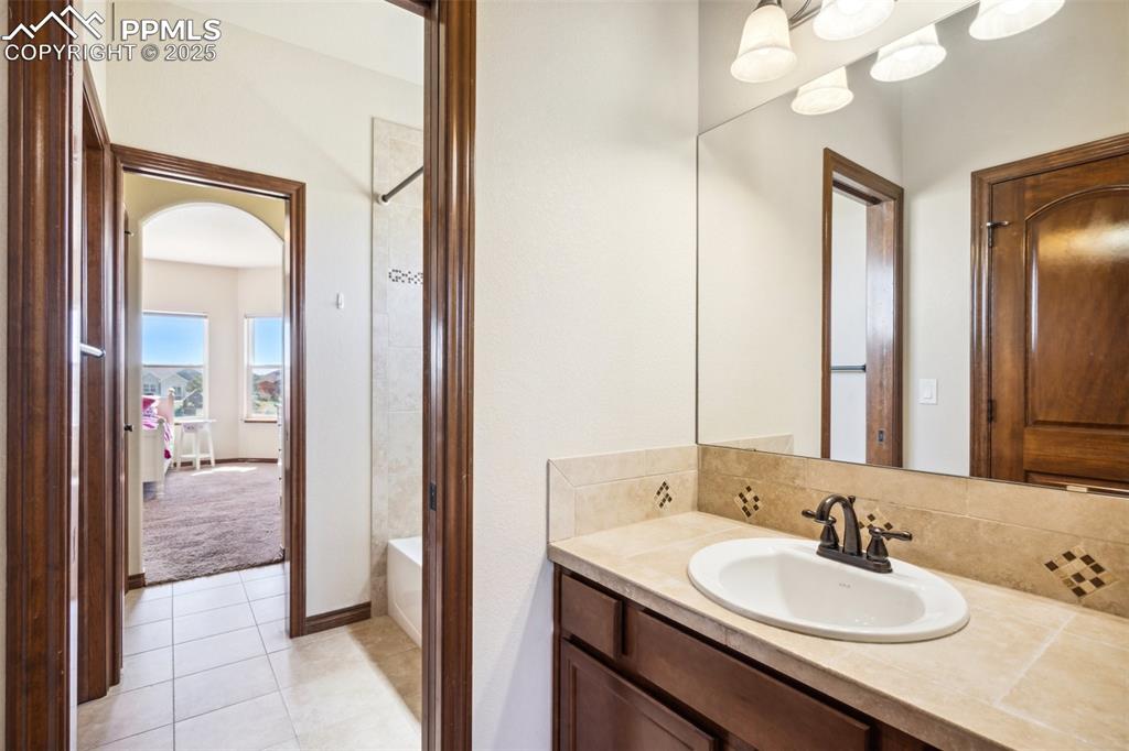 Image 26 of 50: Main level bath, between bedrooms 2 and 3. Each bedroom has a private sink 