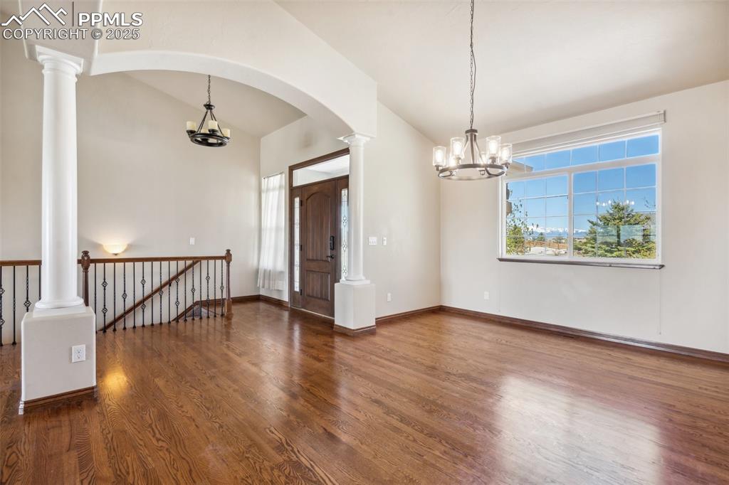 Image 6 of 50: Formal dining room with arches, pillars, wood floors and a mountain view.