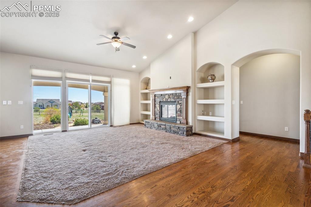 Image 7 of 50: The living room has a fireplace, built-ins and a walk-out to the covered pa