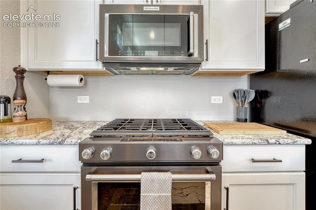 Image 15 of 30: Range with 5-burner gas cooktop.