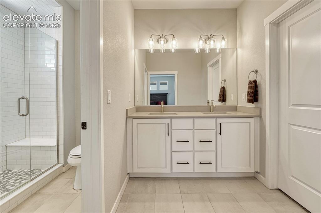 Image 19 of 30: Primary bath with double vanity, walk-in closet...