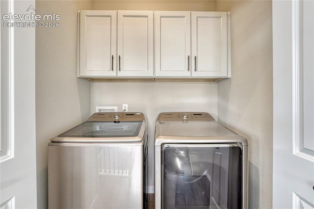 Image 22 of 30: Upper level laundry space with cabinetry...washer and dryer included!