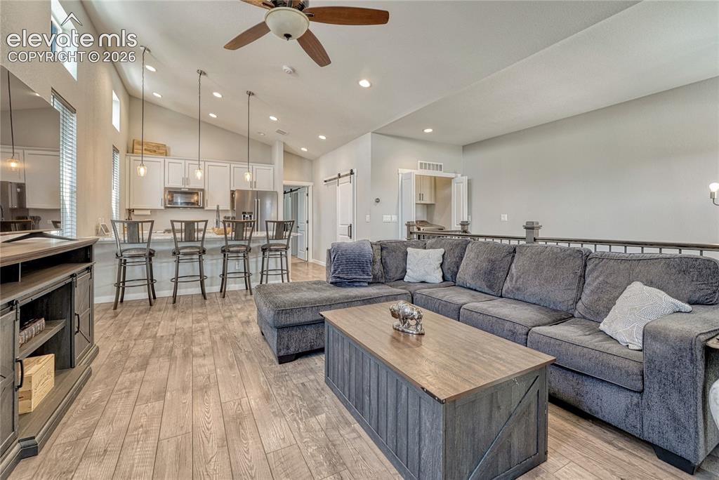 Image 5 of 30: Great room with vaulted ceiling, luxury vinyl flooring...