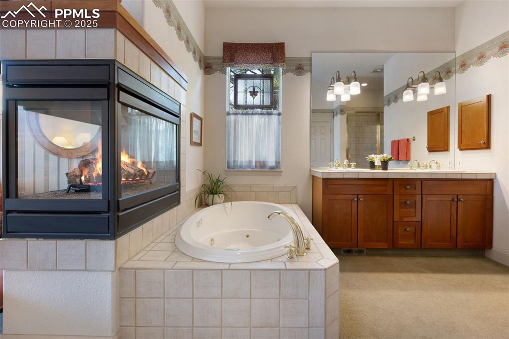Image 17 of 41: Fireplace and jetted tub in 5-pc primary bathroom