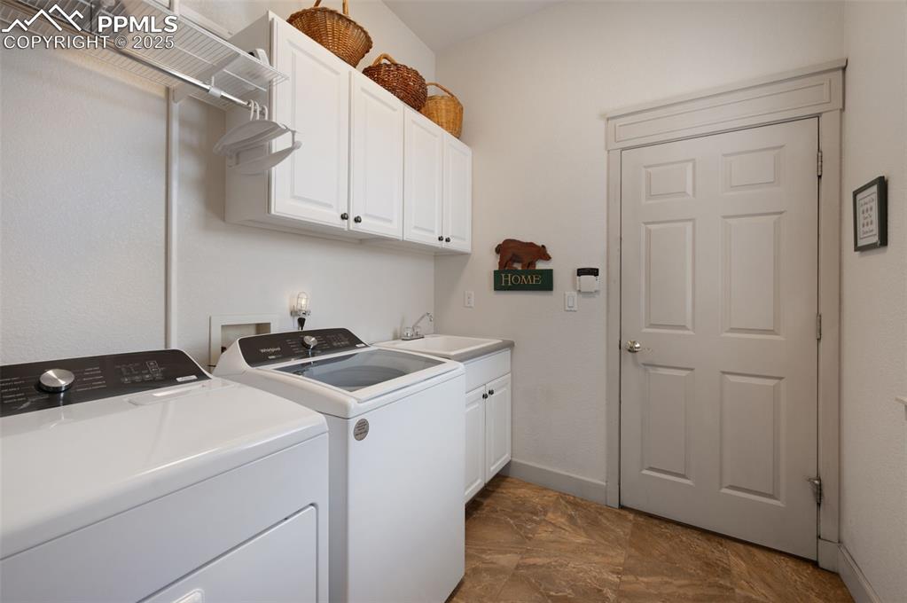 Image 19 of 41: Main-level laundry with utility sink and cabinets