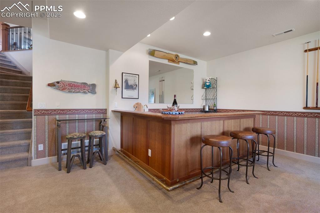 Image 23 of 41: Wet bar with refrigerator in basement game room