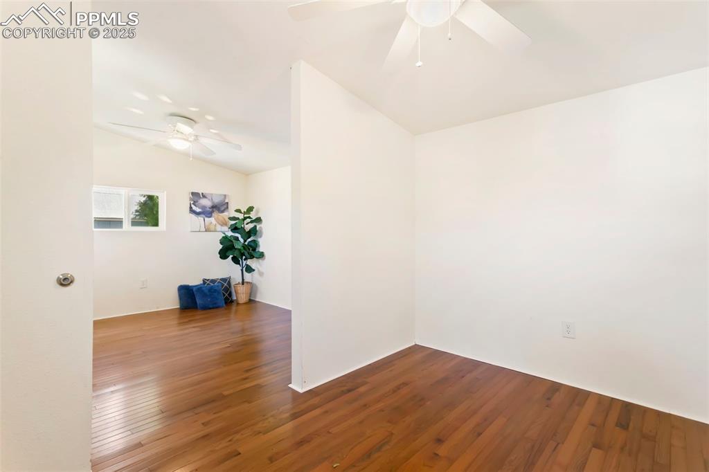 Image 21 of 23: Unfurnished room with dark wood-style floors, ceiling fan, and lofted ceili