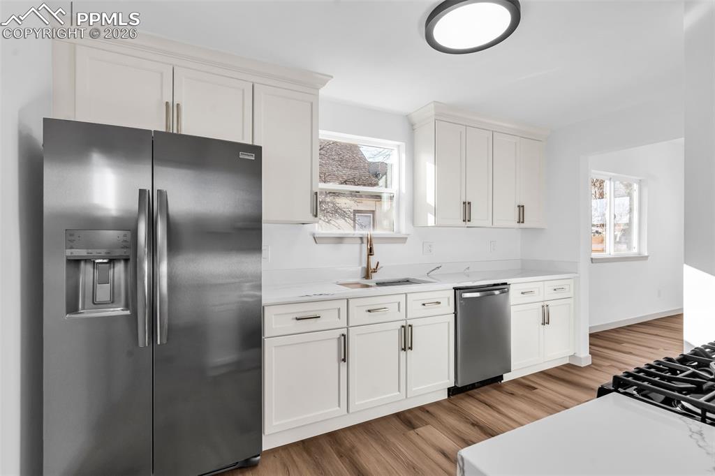 Image 13 of 39: Kitchen featuring stainless steel appliances, light wood-style floors, and