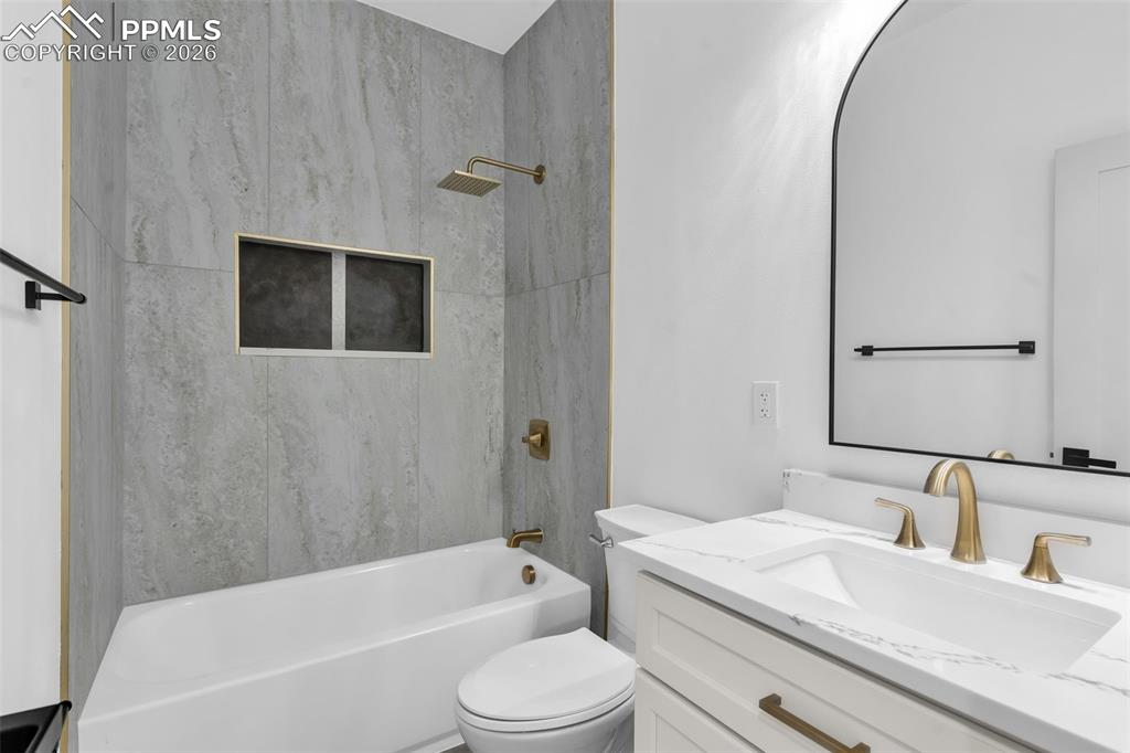 Image 16 of 39: Bathroom featuring vanity and washtub / shower combination