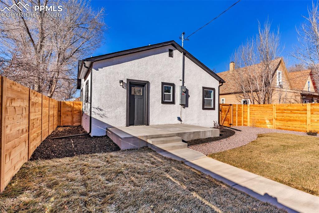 Image 23 of 39: Back of property with stucco siding, a fenced backyard, and a deck
