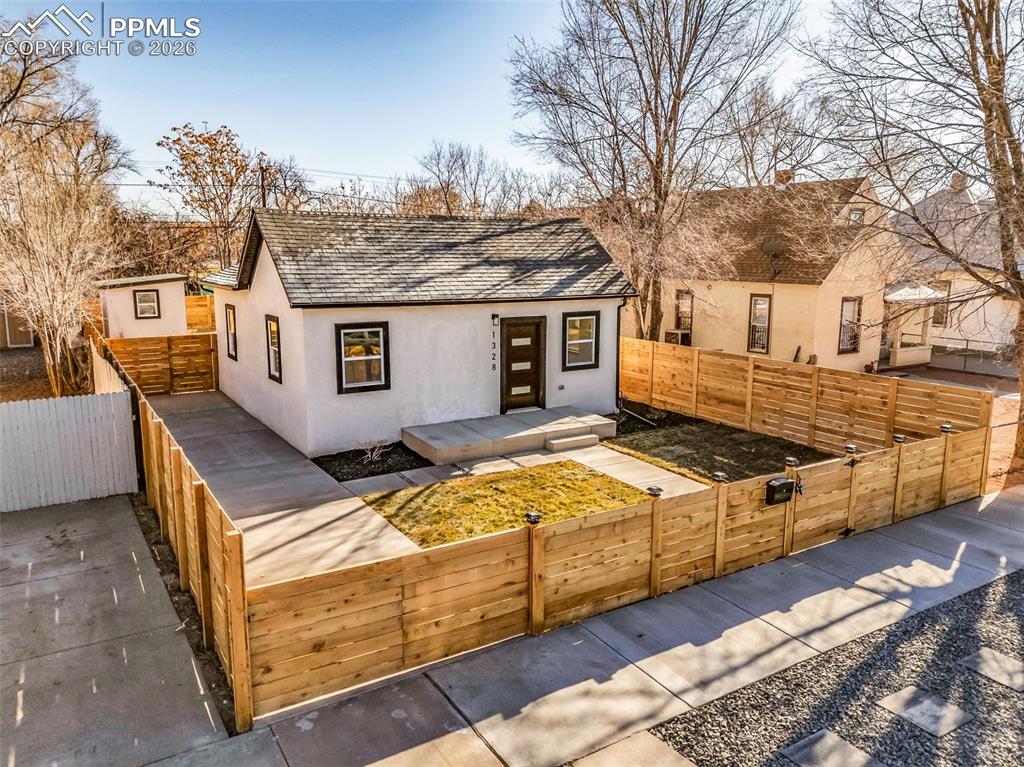 Image 28 of 39: View of front of house featuring a fenced front yard, stucco siding, and ro