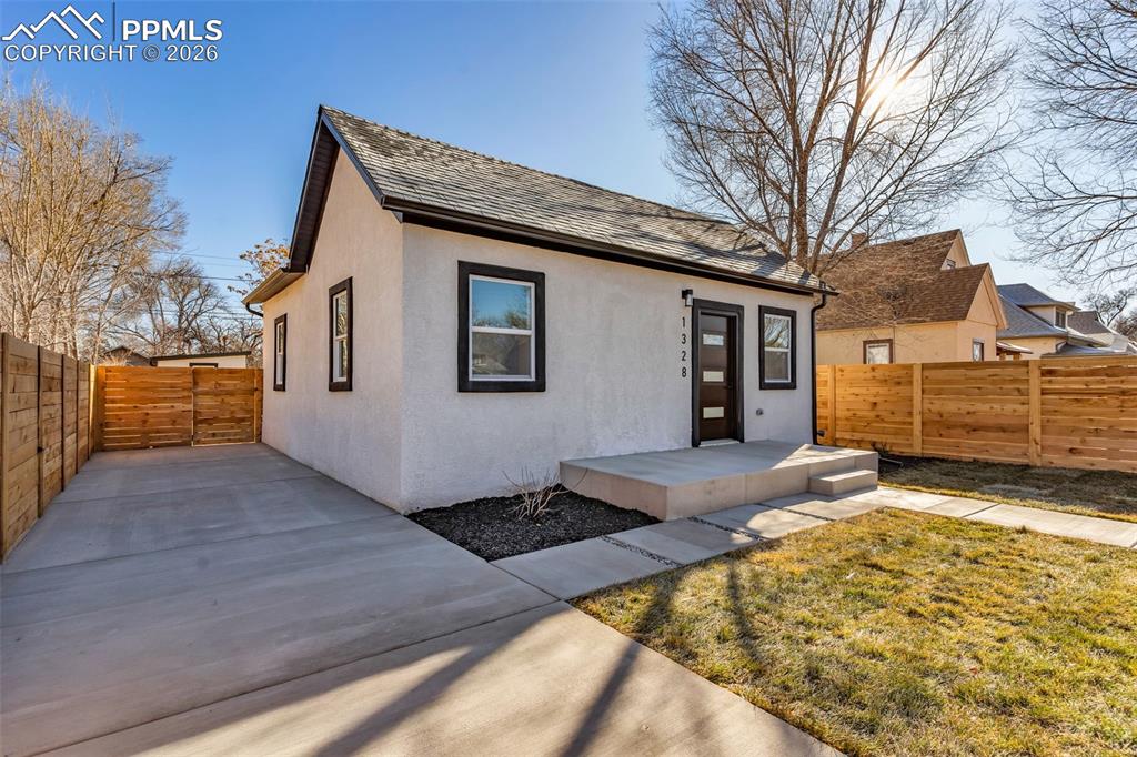 Image 4 of 39: View of front facade featuring a fenced backyard, stucco siding, and a shin