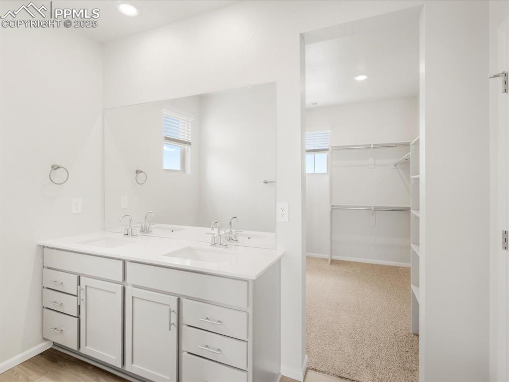 Image 25 of 40: Full bathroom with double vanity, baseboards, and recessed lighting