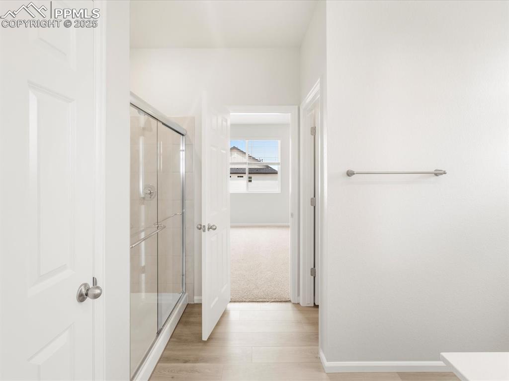 Image 26 of 40: Hall with baseboards and light wood finished floors