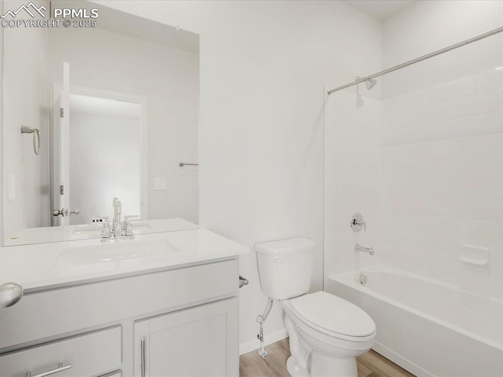 Image 32 of 40: Bathroom with toilet, vanity, wood finished floors, shower / bathtub combin
