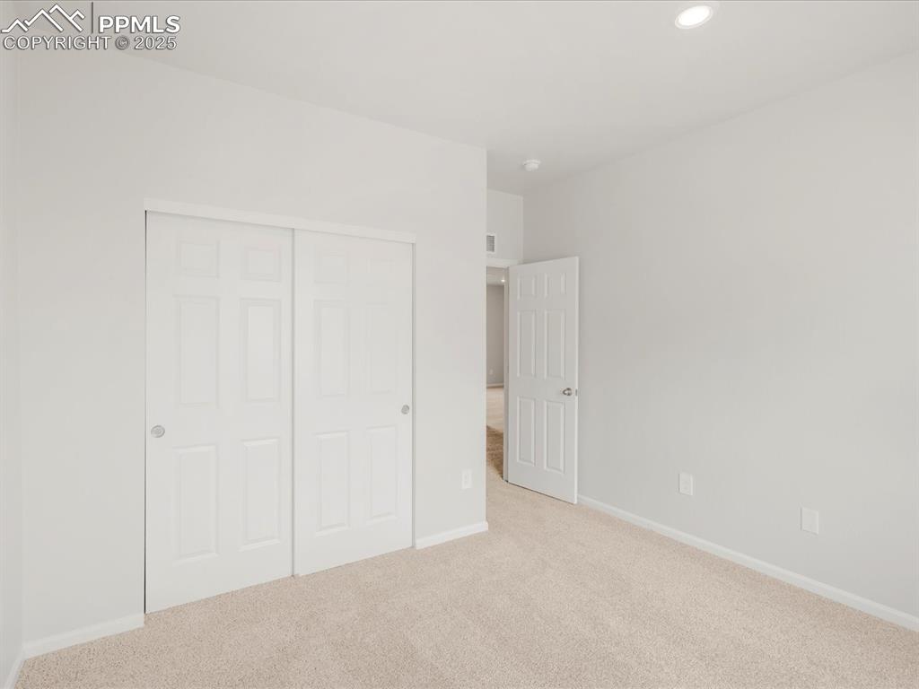 Image 34 of 40: Unfurnished bedroom with carpet flooring, a closet, baseboards, and recesse