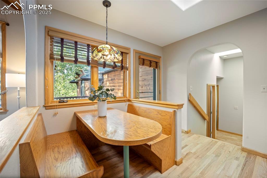 Image 10 of 33: Dining room with arched walkways and wood finished floors