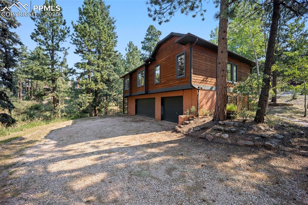 Image 23 of 33: View of property exterior with an attached garage and driveway