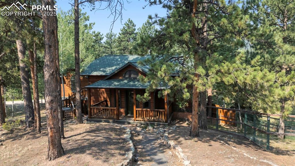 Image 29 of 33: Chalet / cabin with covered porch and a shingled roof