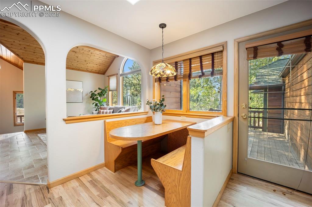 Image 9 of 33: Dining space featuring vaulted ceiling, wood ceiling, light wood finished f