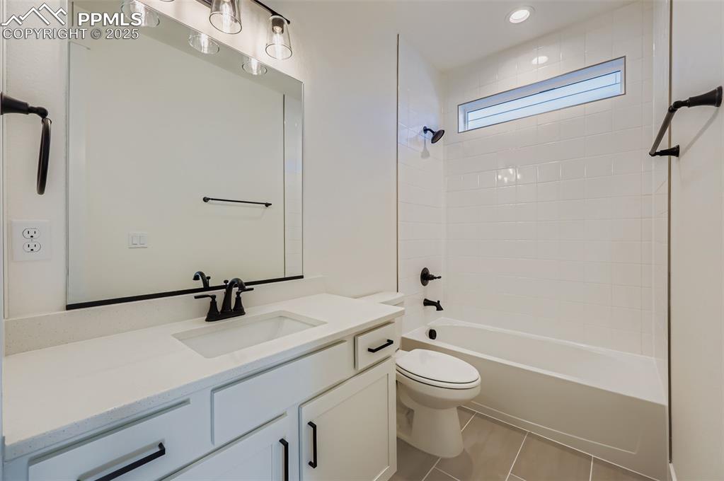 Image 17 of 28: Bathroom featuring vanity,  shower combination, and light tile patterned fl