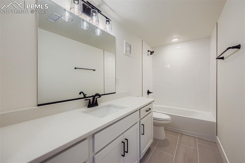 Image 24 of 28: Full bath with vanity, light tile patterned floors, and shower / washtub co