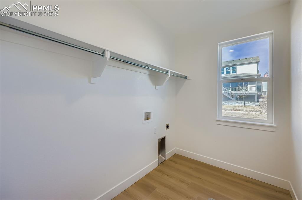 Image 25 of 28: Laundry room featuring light wood finished floors, electric dryer hookup, a