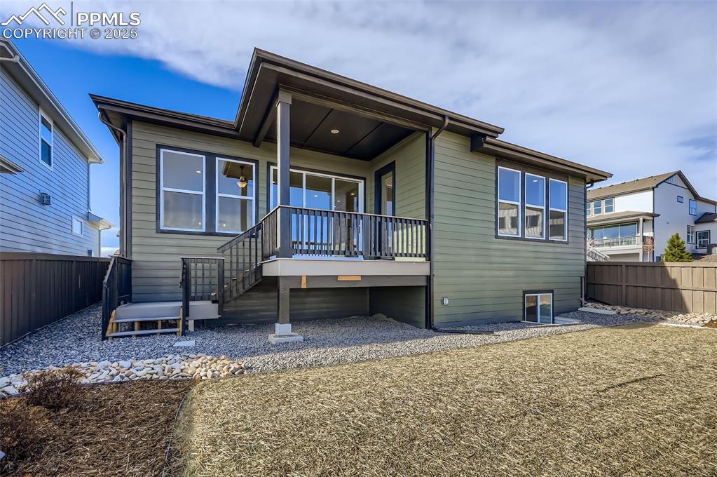 Image 27 of 28: Rear view of house featuring a fenced backyard, a wooden deck, and stairway