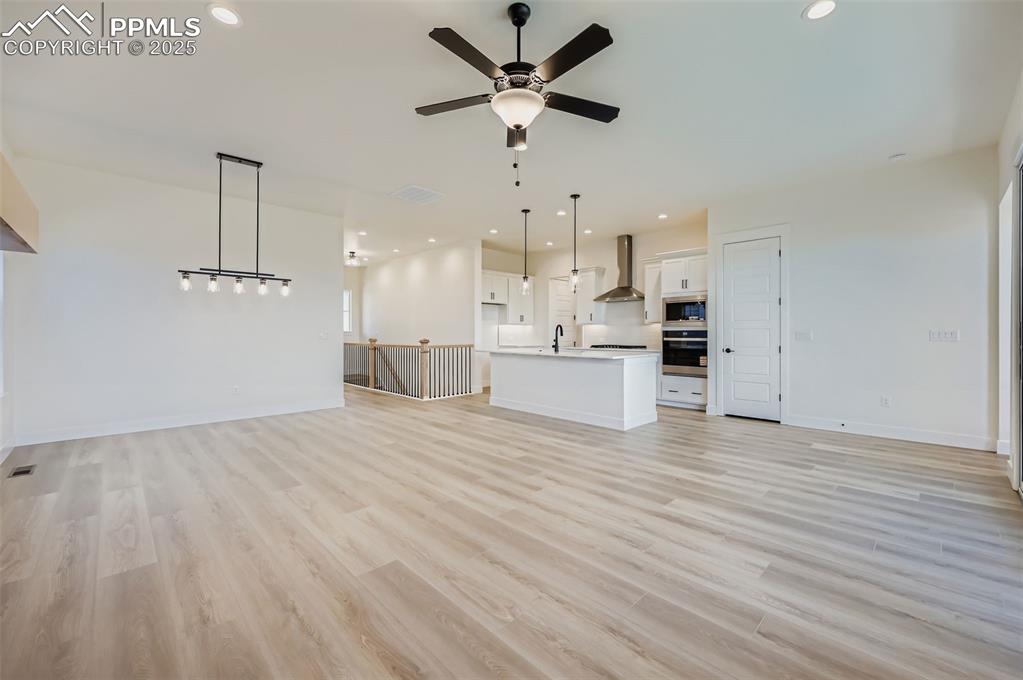 Image 4 of 28: Unfurnished living room with recessed lighting, light wood-style floors, an