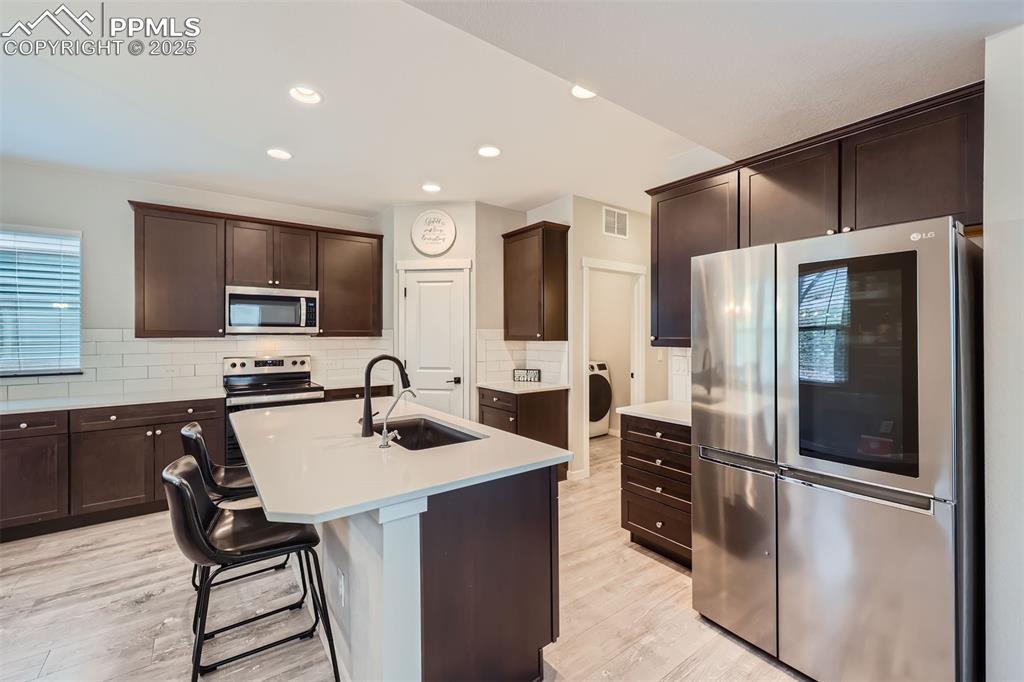 Image 14 of 46: Stainless steel appliances, quartz countertops, pantry, island, gourmet kit