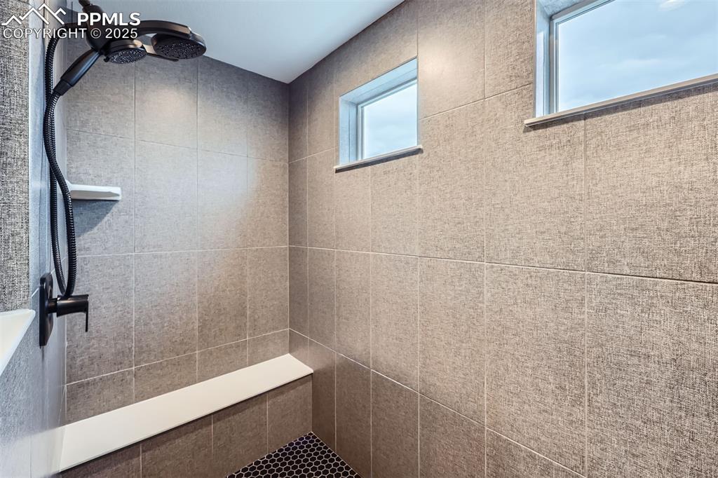 Image 22 of 46: Walk-in shower in primary suite bath.